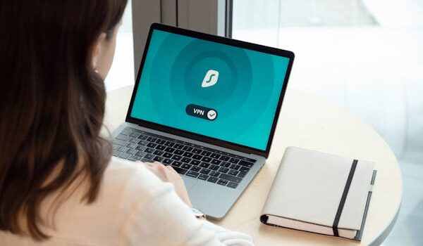 A woman working on a laptop with a VPN icon on screen for secure online browsing.